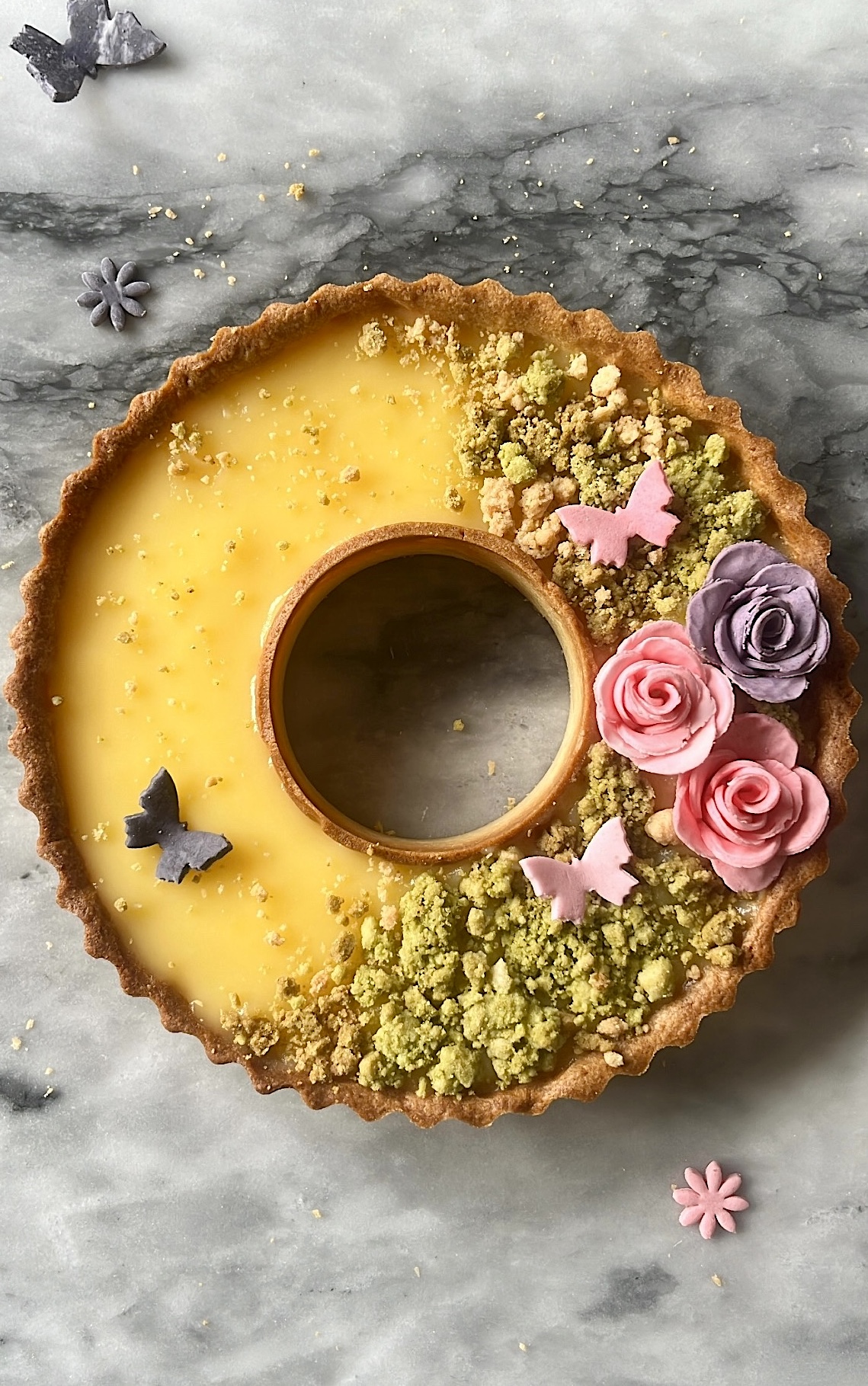 Lemon tart topped with grassland-like decoration made of sugar toppings.