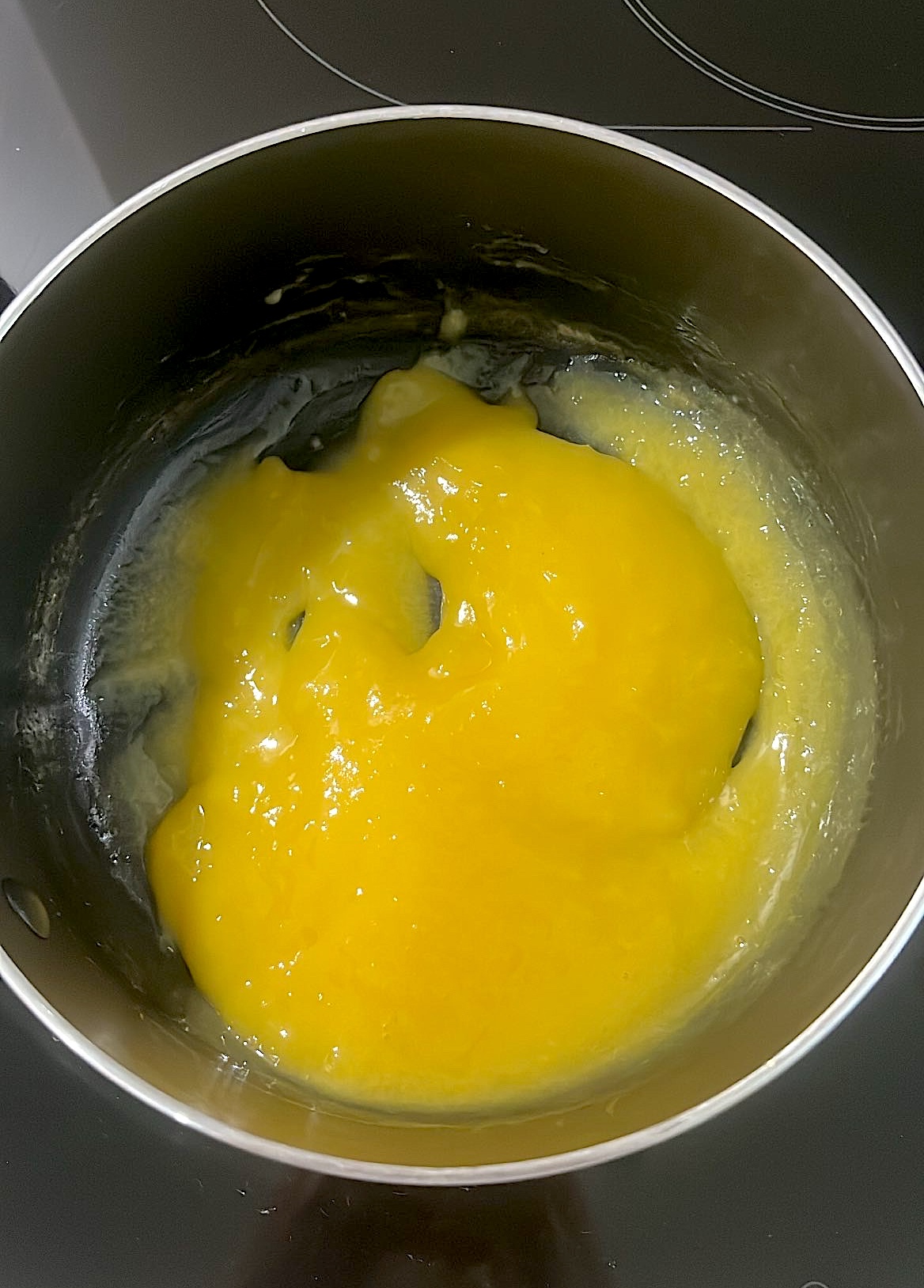 Lemon filling mixture being stirred in a saucepan to thicken