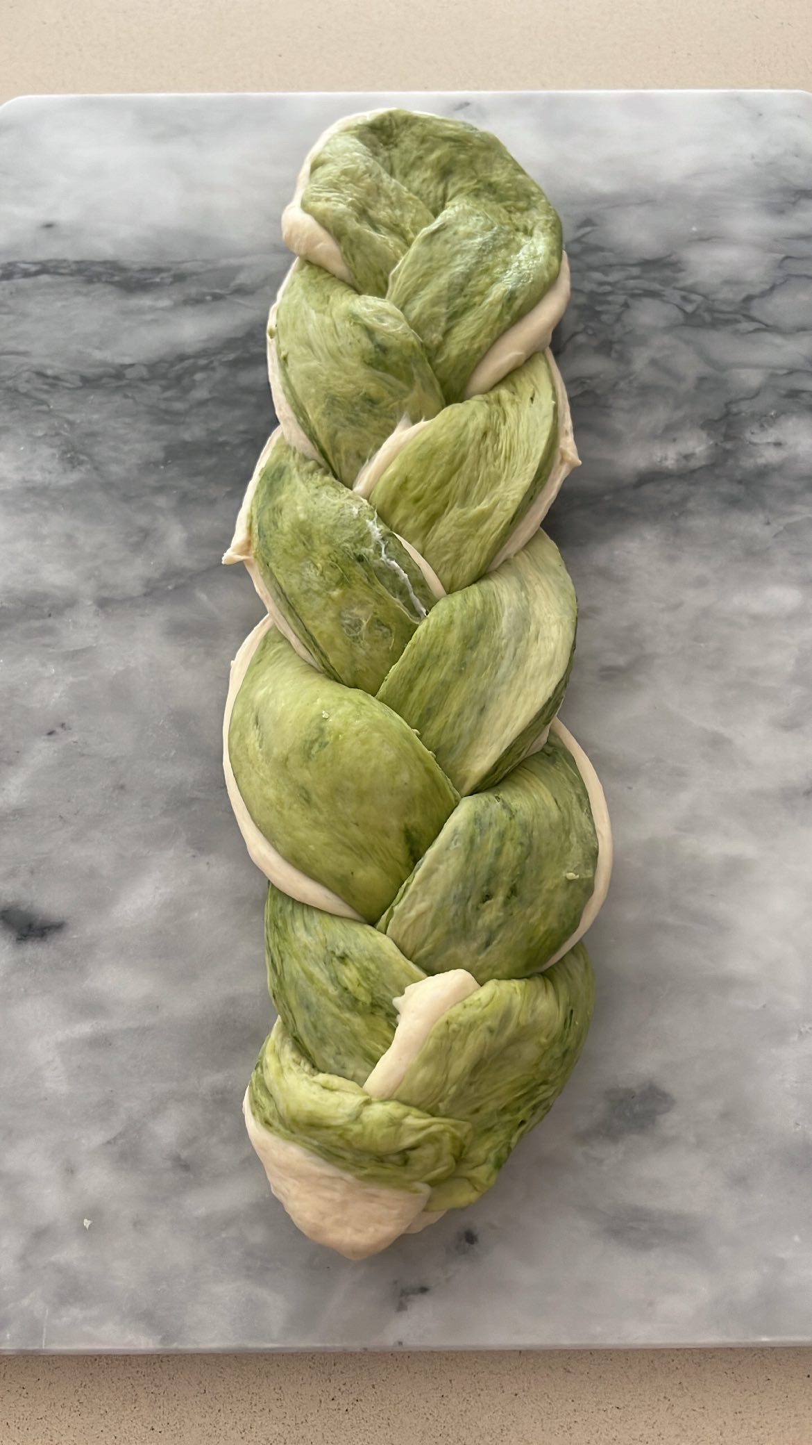 Stacking and braiding the plain and matcha dough to form a loaf